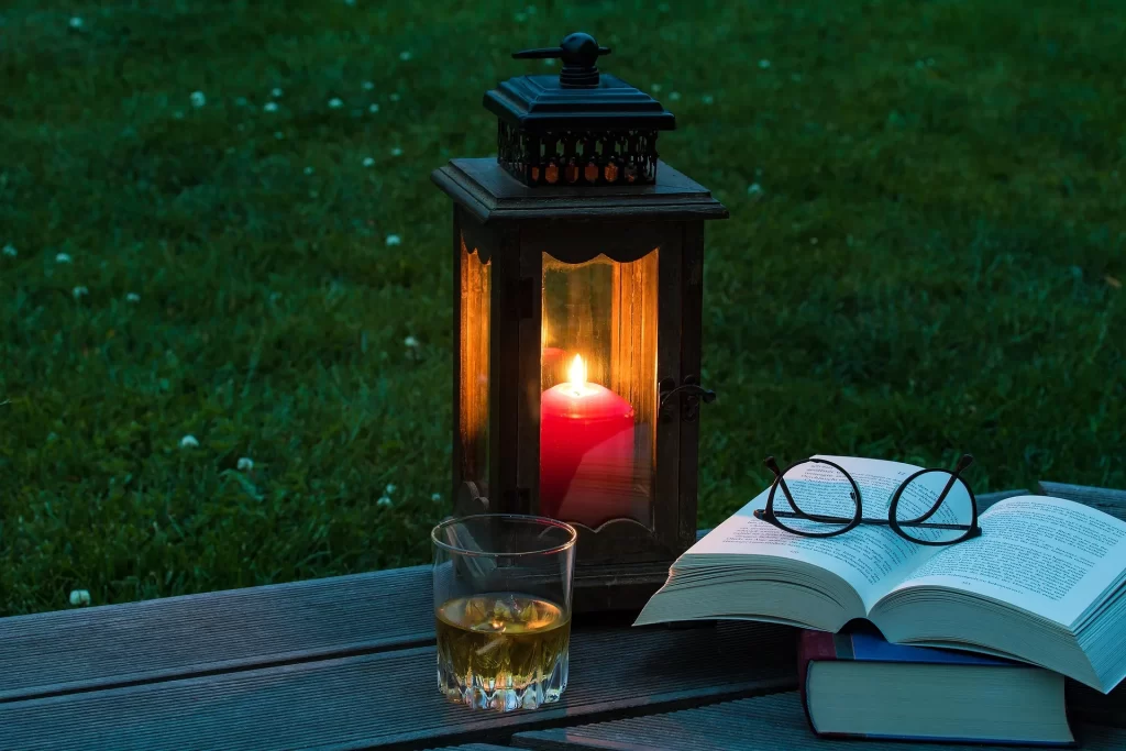 Boek en kaarslicht in de avond, passend bij ontspannen zonder schermen voor het slapengaan.
