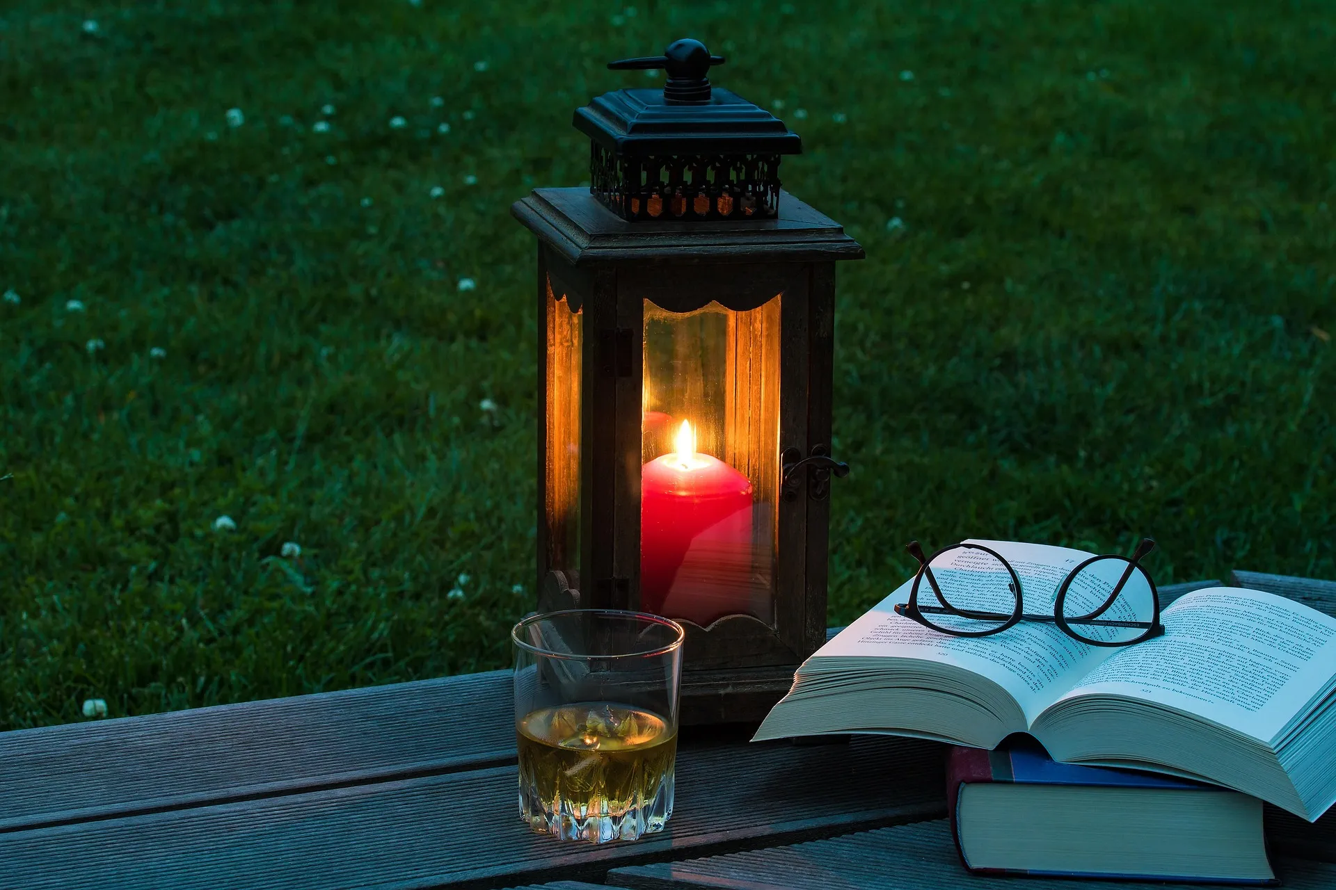 Boek en kaarslicht in de avond, passend bij ontspannen zonder schermen voor het slapengaan.